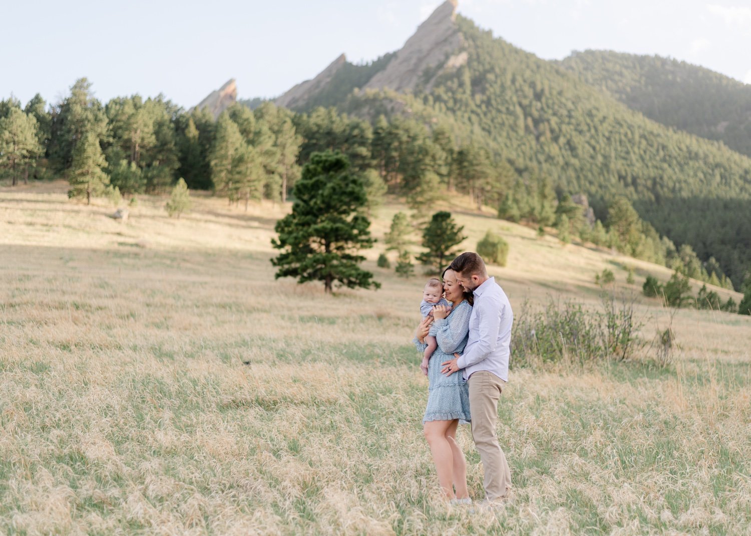Young couple and their baby infant of the Flatirons in in Chautauqua Park located in Boulder Colorado