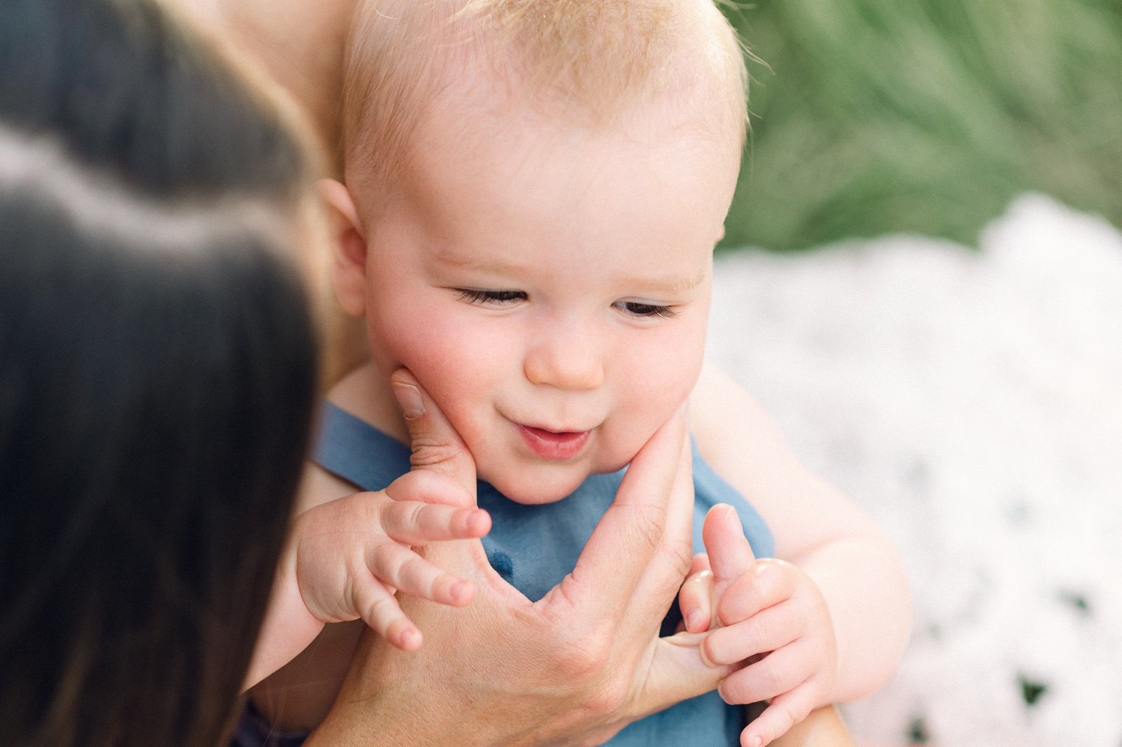 Mom squeezing baby boy's cheeks during a photoshoot near Denver Colorado