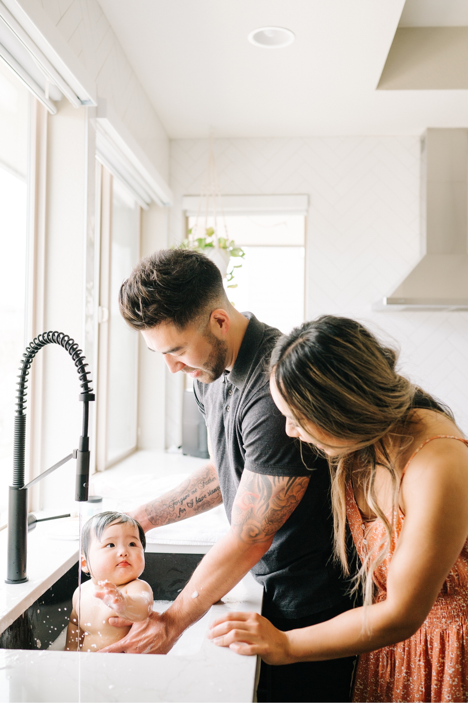 6 month old bath time session with mom and dad playing with baby in Denver Colorado