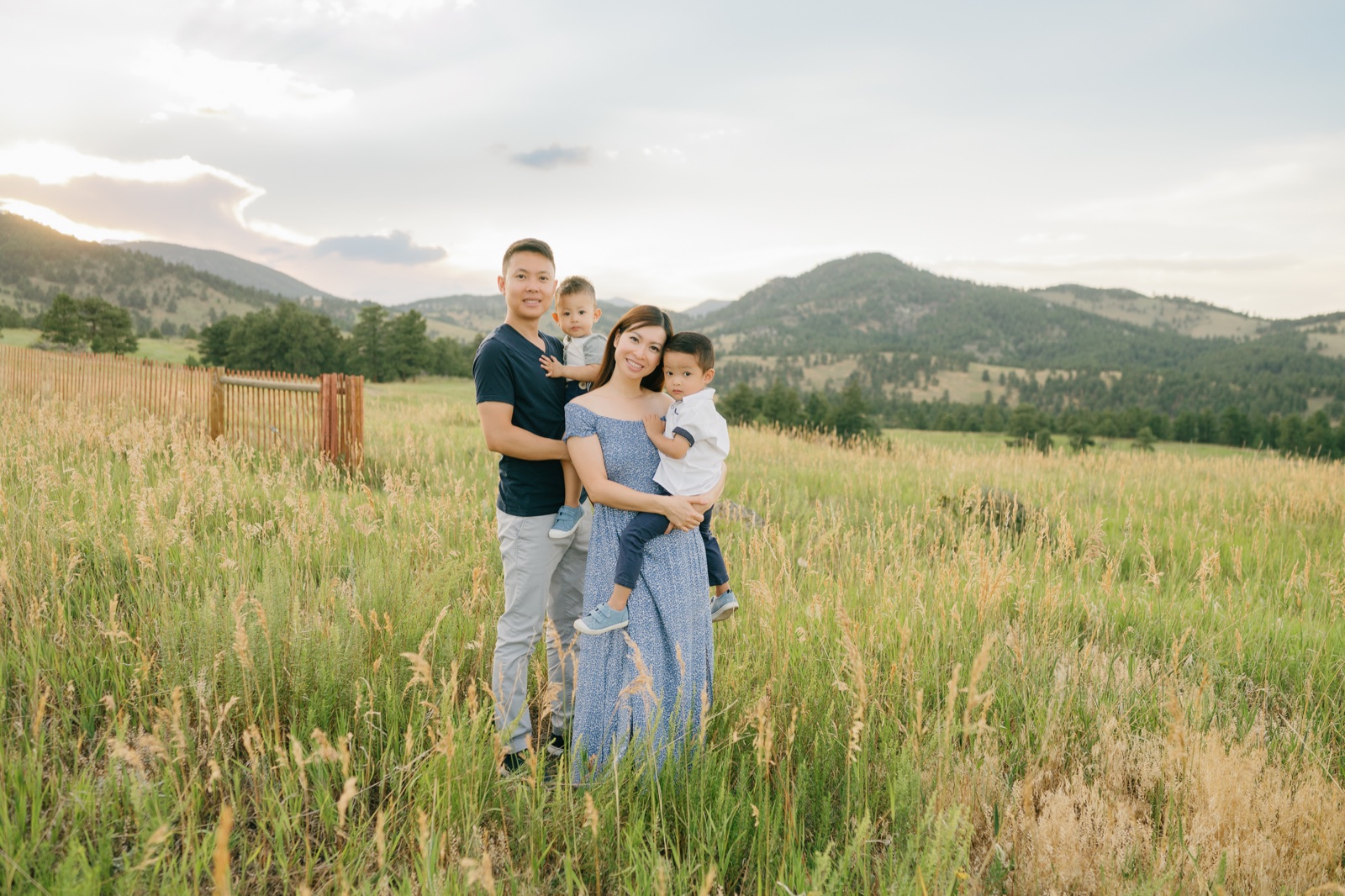 Family of four wearing shades of blue and gray during a sunset photoshoot outside of Boulder County