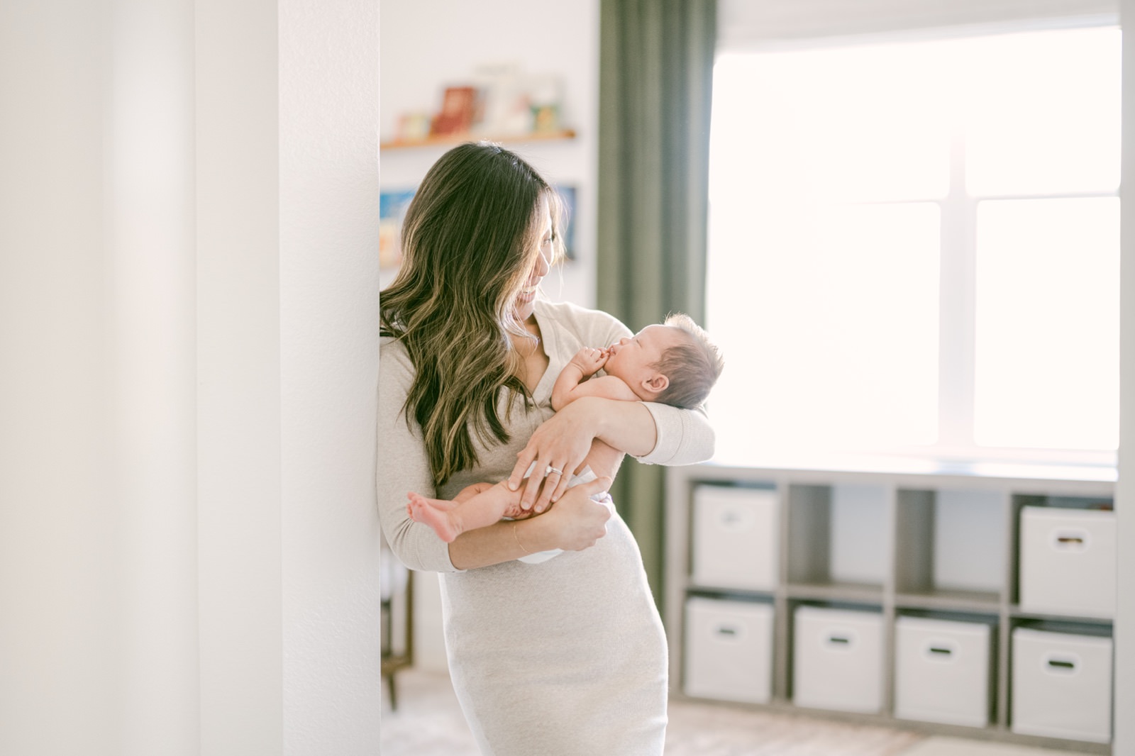 Tender moment shared between Denver mom and her older newborn baby during a photoshoot