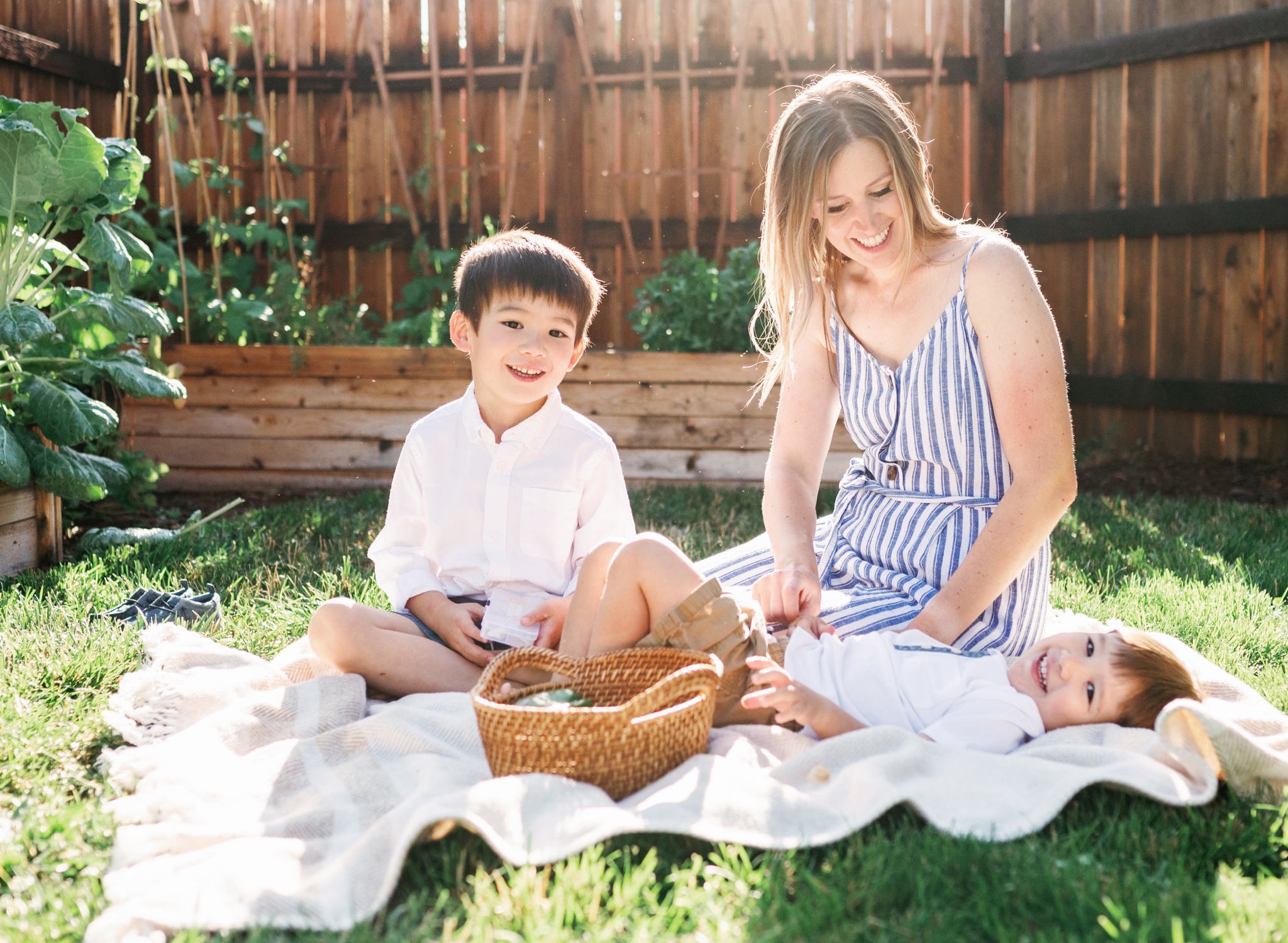 A young mother and her sons having fun in their vegetable garden in Denver Colorado during a motherhood photoshoot