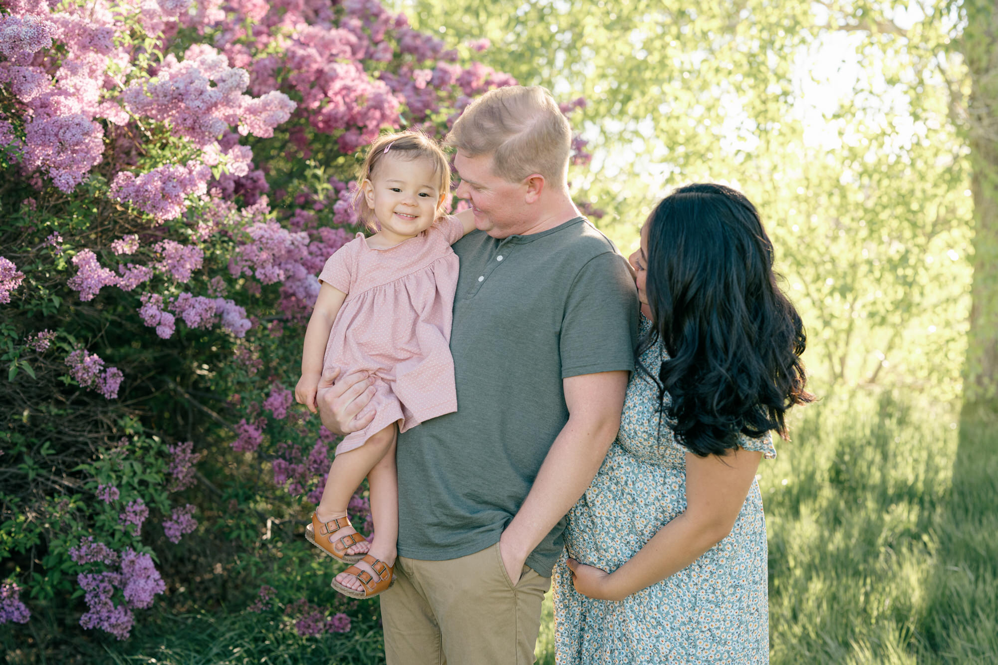 Spring Family Photos in Denver with a family of 3 with purple lilacs in the background